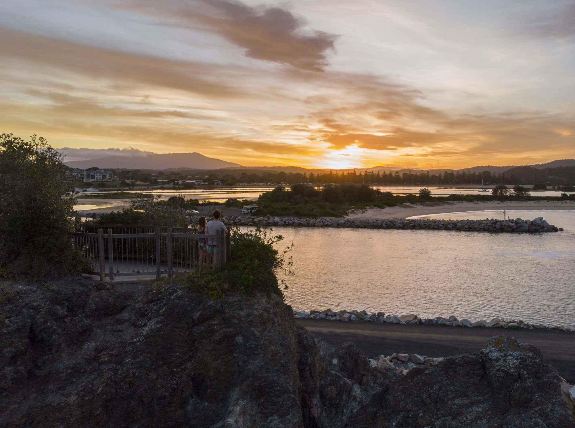 Couple watching the sunset from Bar Rock Lookout, Narooma.