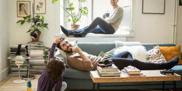 Young girl playing with her dads in the lounge room.