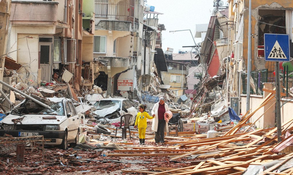 There has been another earthquake in Turkey. This image shows a woman and a young girl walking through the rubble in Hatay.