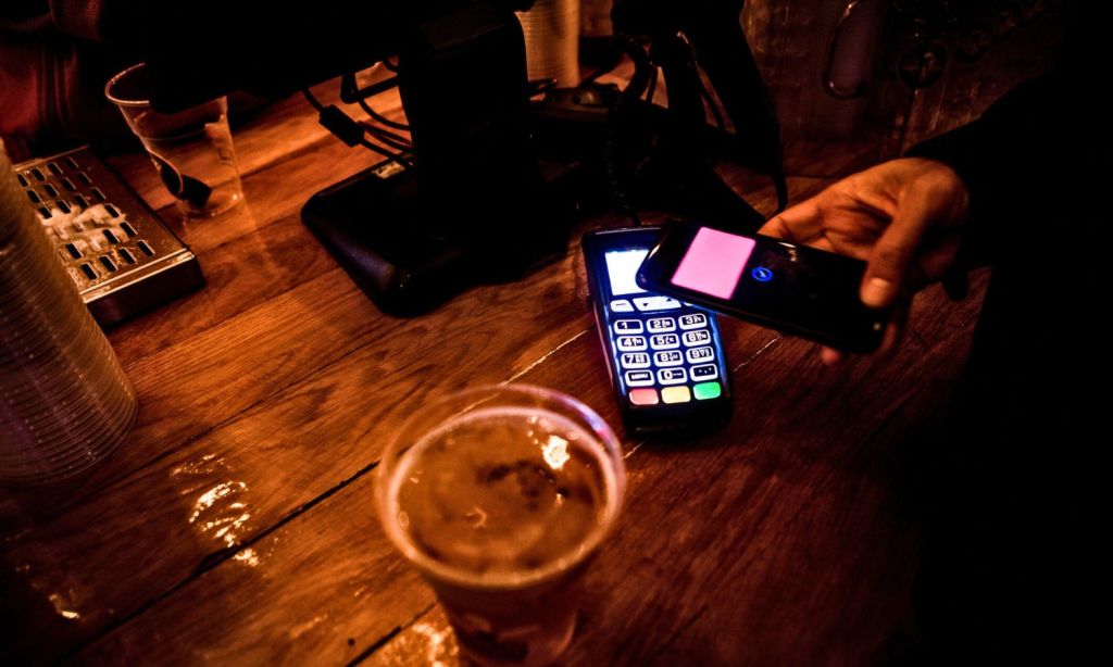 An image showing someone paying for beer.