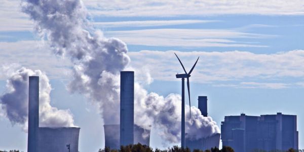 An image showing a wind generator in front of a coal fired power station
