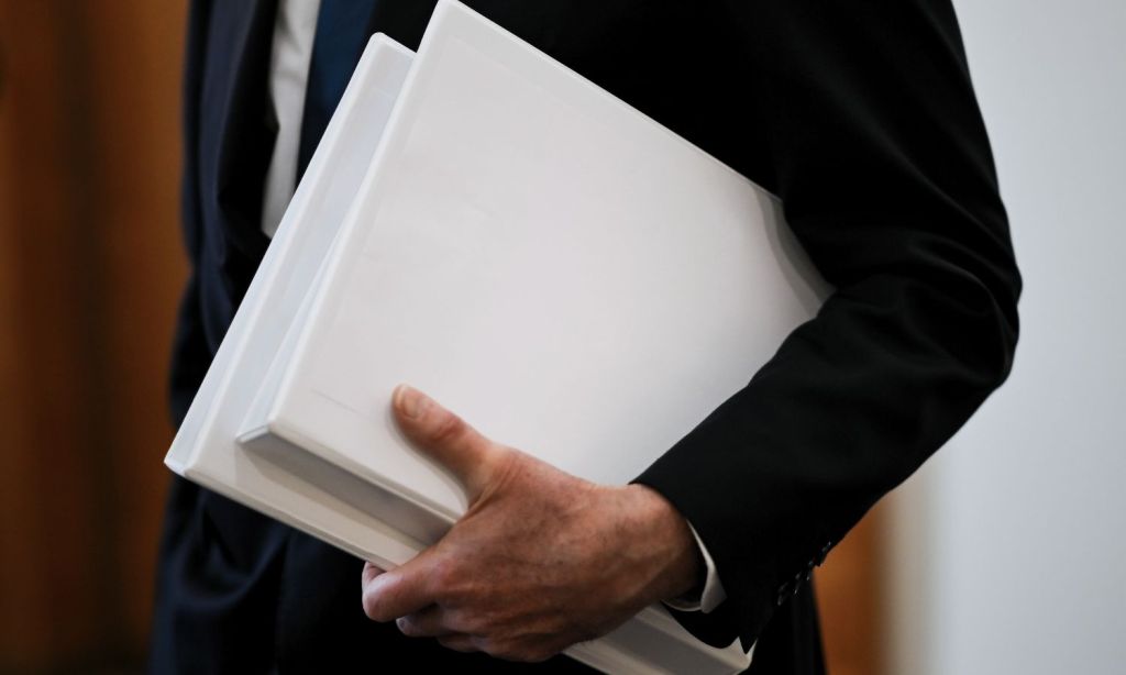 An image showing a politian holding a file to illustrate the secret ONI report that the Australian government will not release